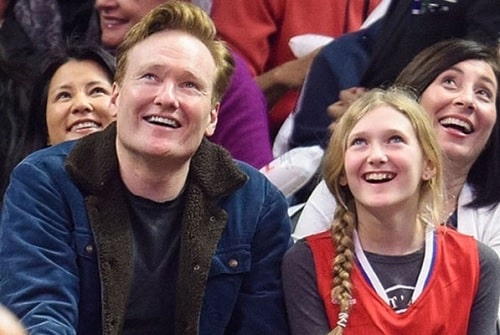 A picture of Neve O'brien attended the Los Angeles Clippers' match at the Stapples areba with her father, Conan O'Brien .